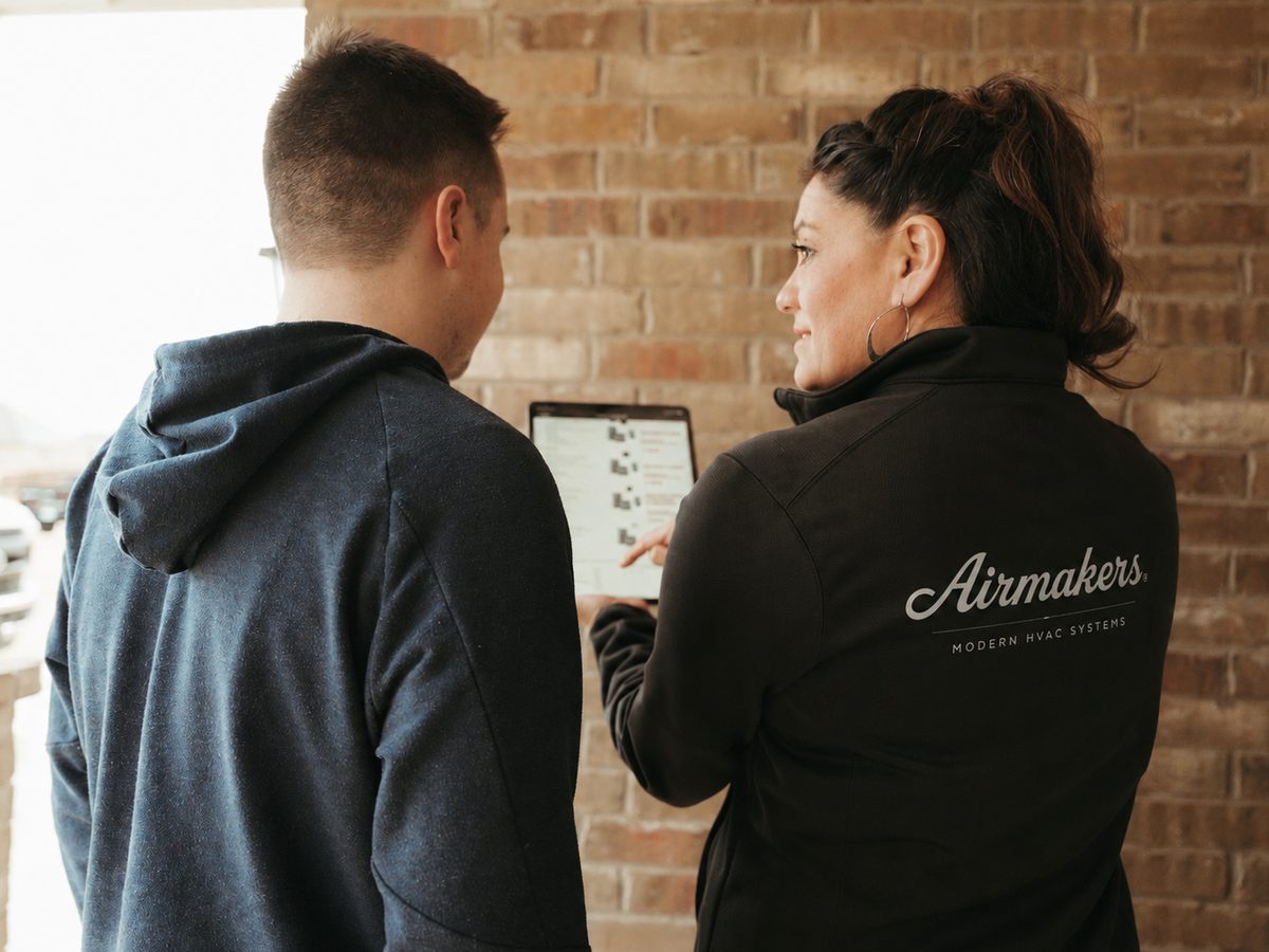 Airmakers technician explaining upfront pricing to a homeowner